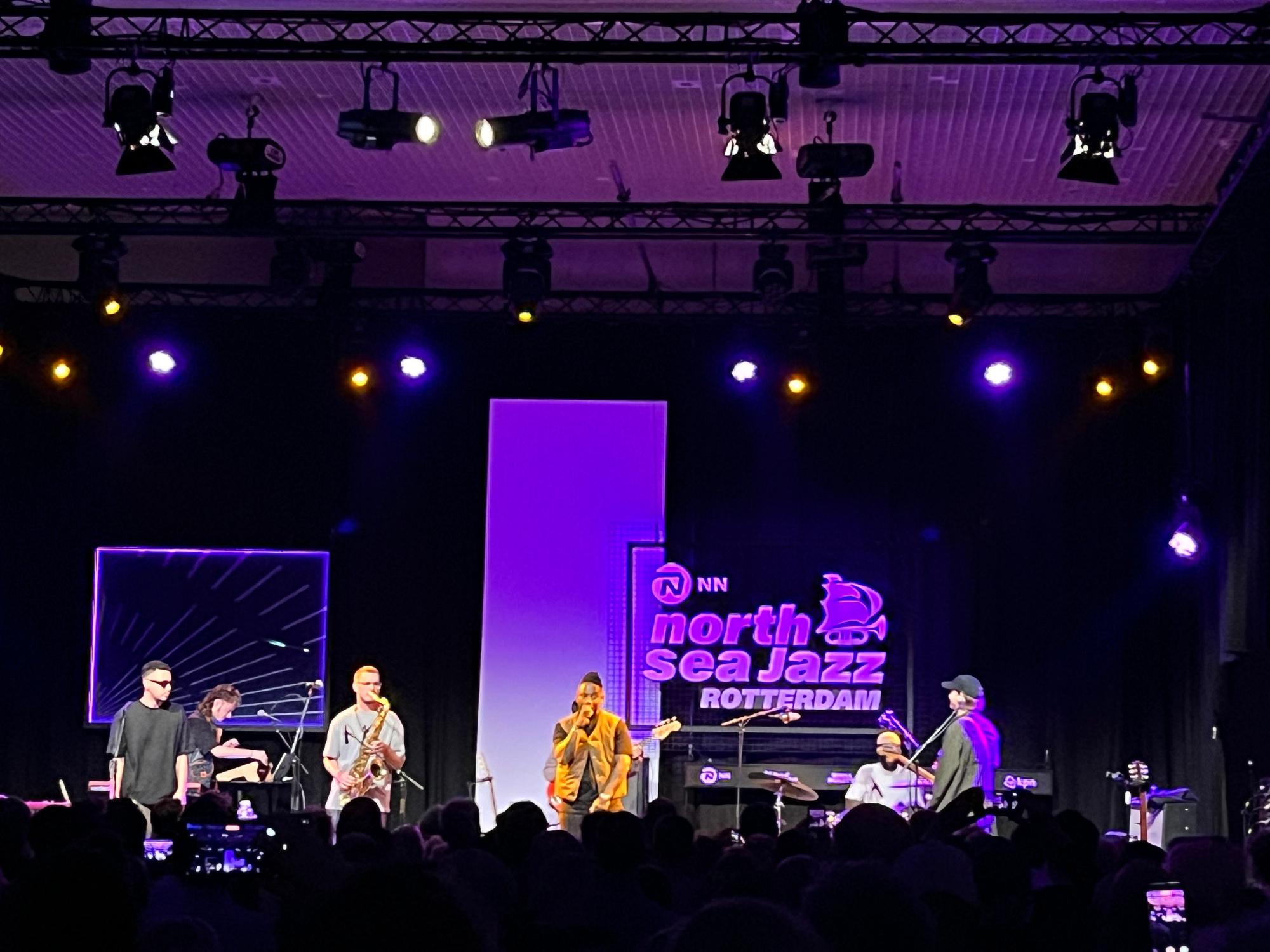 band on stage with rapper in middle