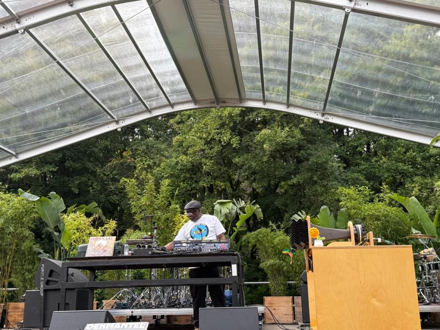 Mad Professor on stage in greenhouse surrounded  by plants and trees