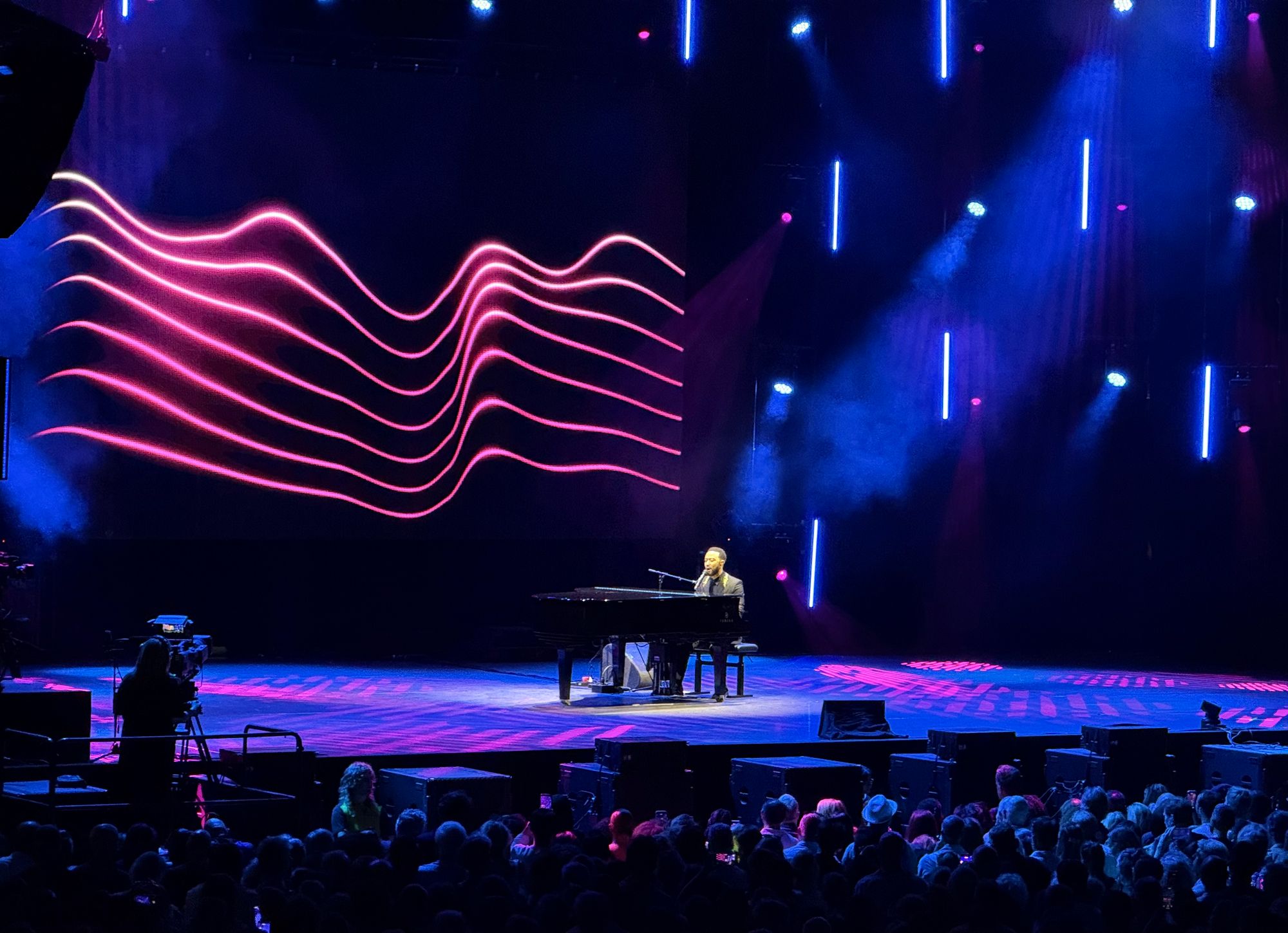 John alone on stage playing a grand piano