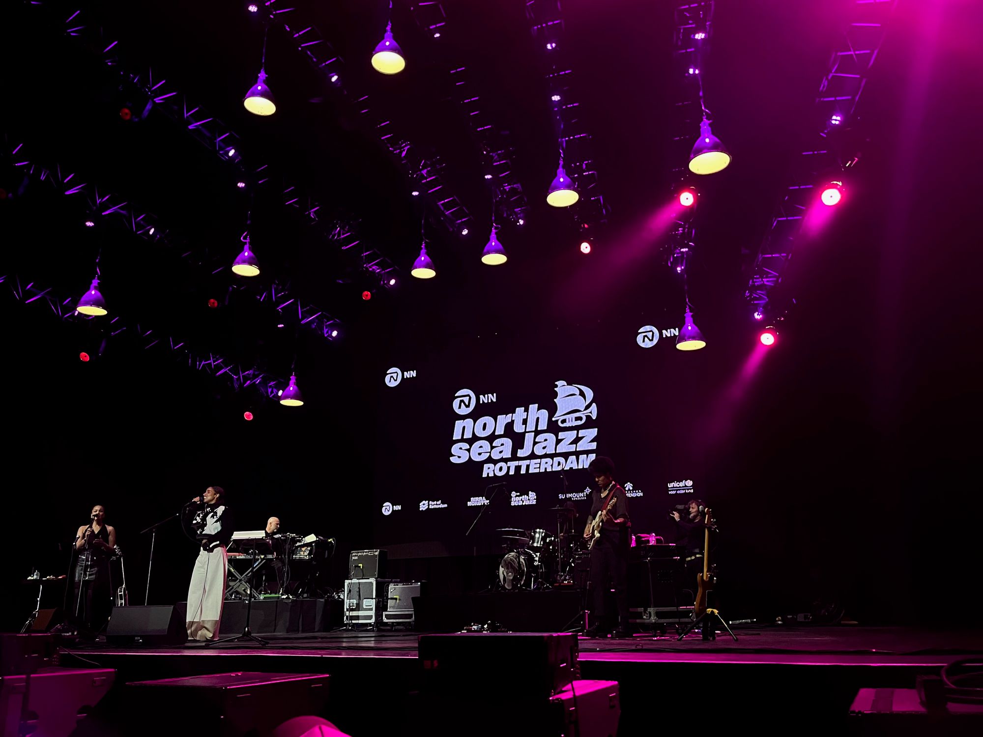 Lianne on stage, above are purple lights and behind a banner of North Sea Jazz Rotterdam