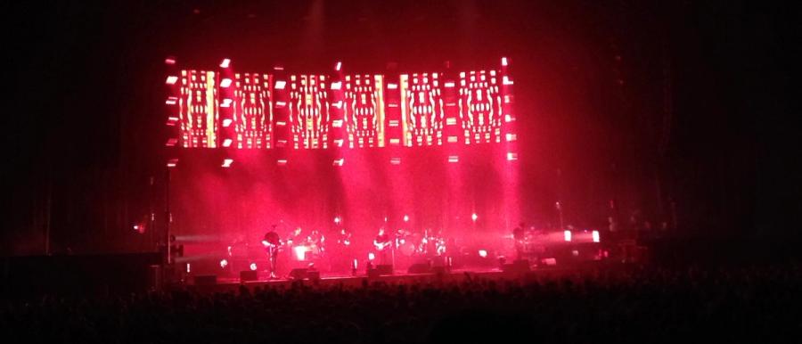 vague picture of Radiohead on stage in red lights
