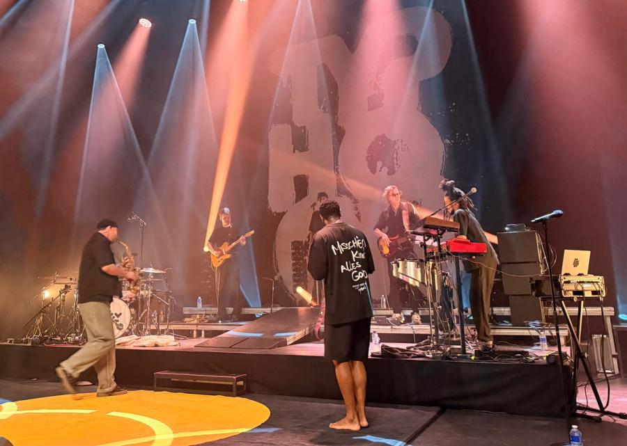 typhoon with a shirt that says 'misschien komt alles goed' on the back; on the left  is his saxophone player and rest of band