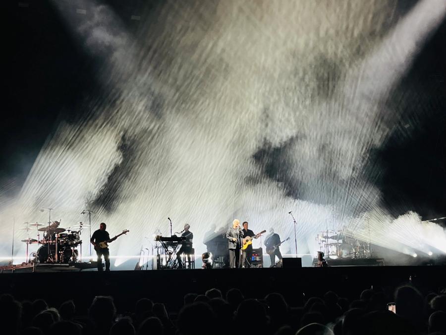 elizabeth fraser in front of stage, because of the stage lights it's all black and white with a lot of white smoke behind 