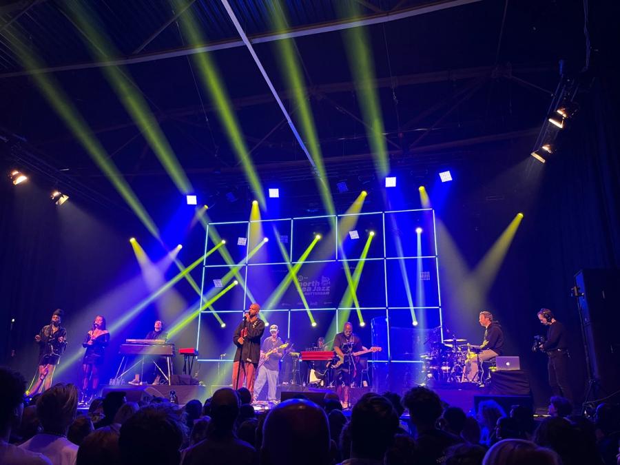 sef with full band on stage with green and blue lights