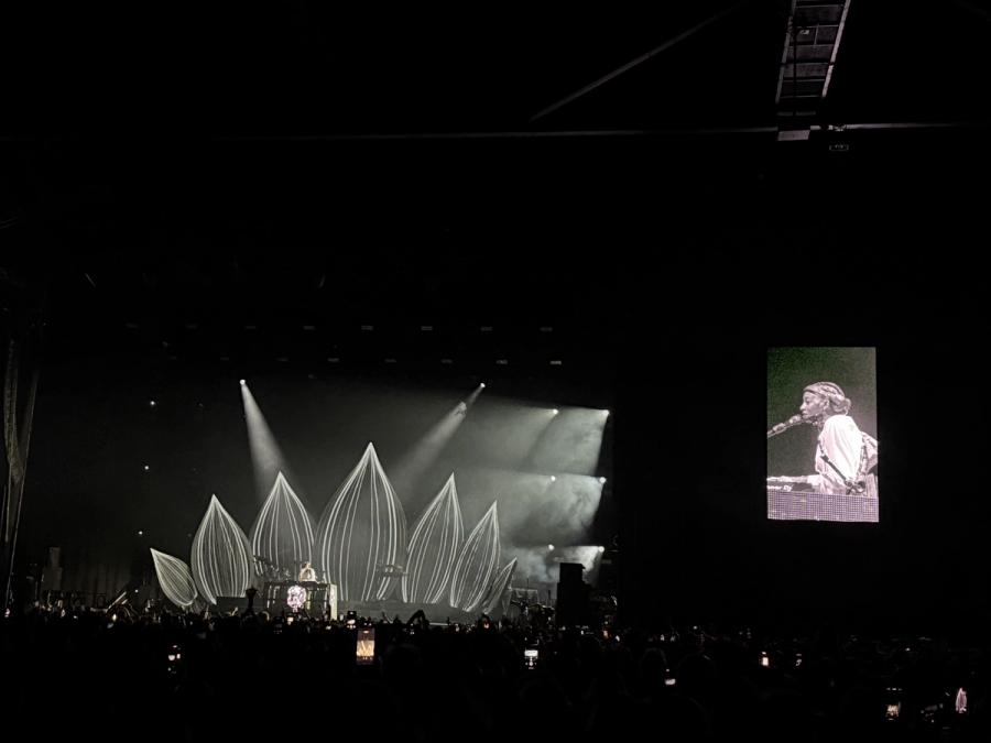 Simz behind DJ booth that features the head from Drop 7, on the right there's a video stream of her DJing