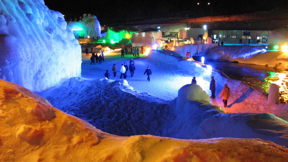 層雲峽冰瀑祭的夜間會場,打上藍光的冰牆與冰柱沿著河岸排開,遊客在雪地走道上散步