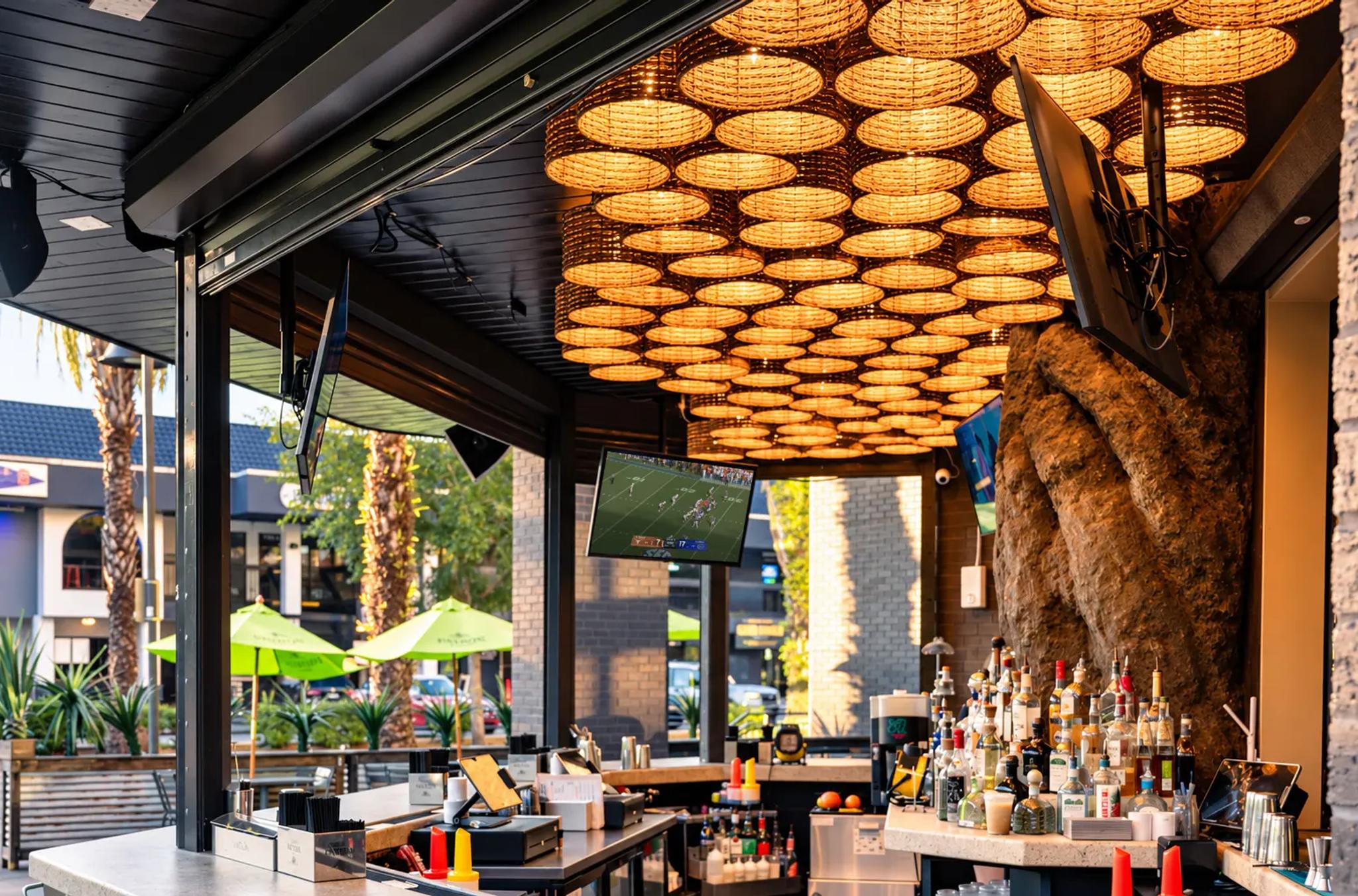 The Cantina Añejo patio bar under woven pendant lights