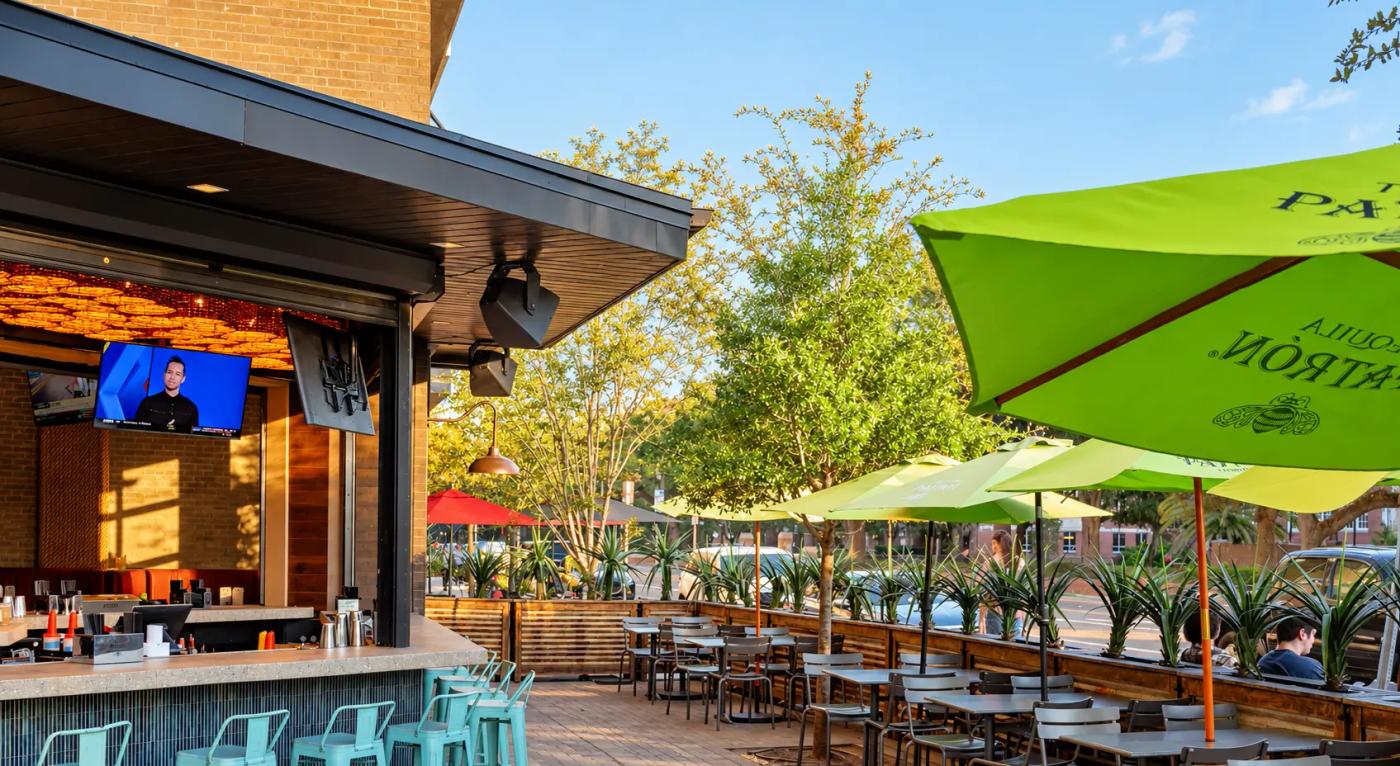 The Cantina Añejo patio and bar under green Patrón umbrellas