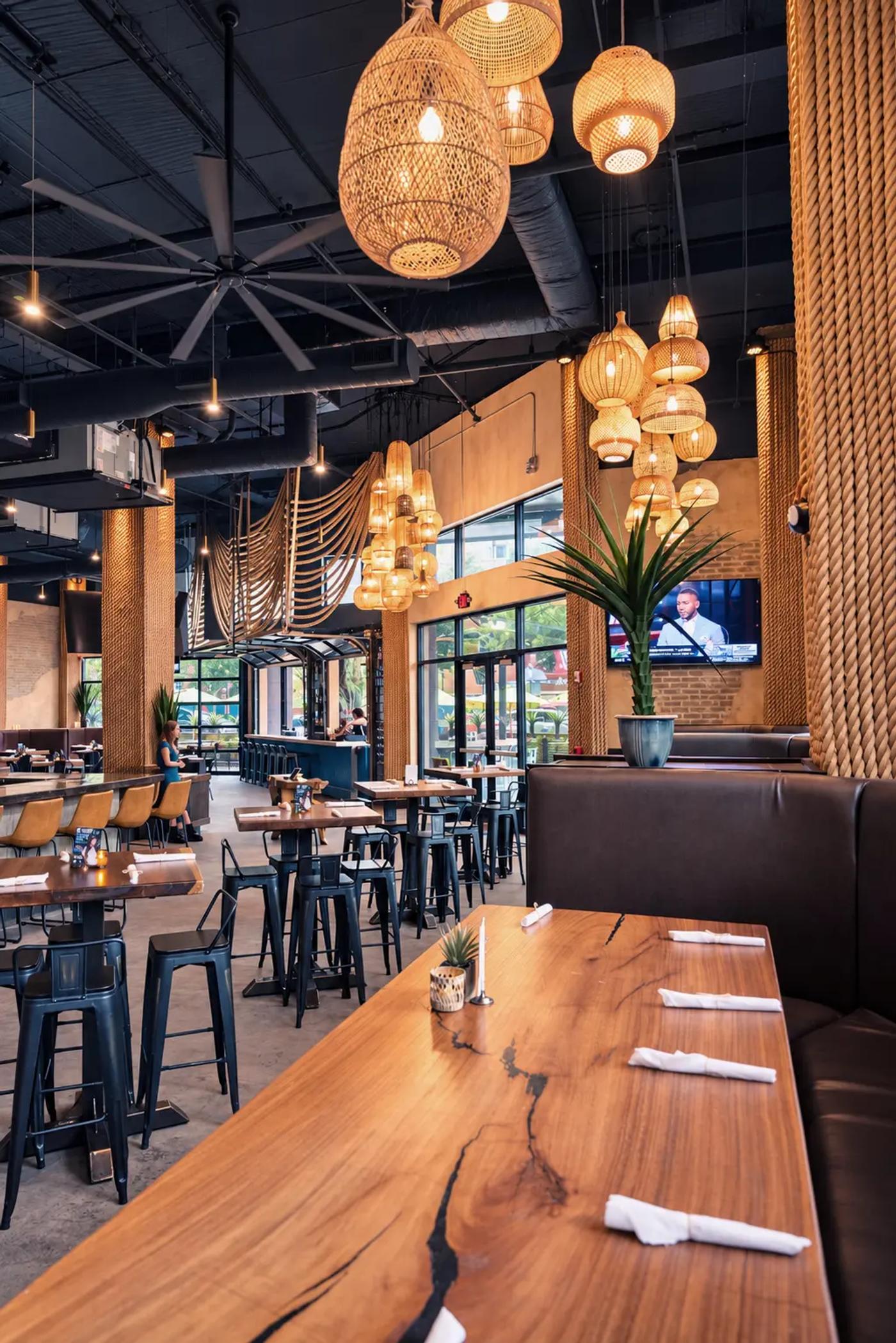 The long live-edge table under woven pendant lights in the Cantina Añejo dining room