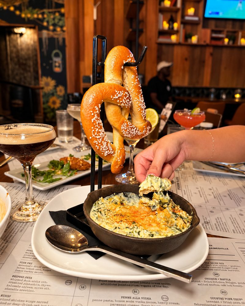 Warm pretzel with kale and artichoke dip