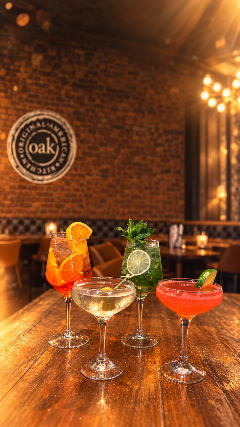 Four cocktails on a wooden table under the OAK seal