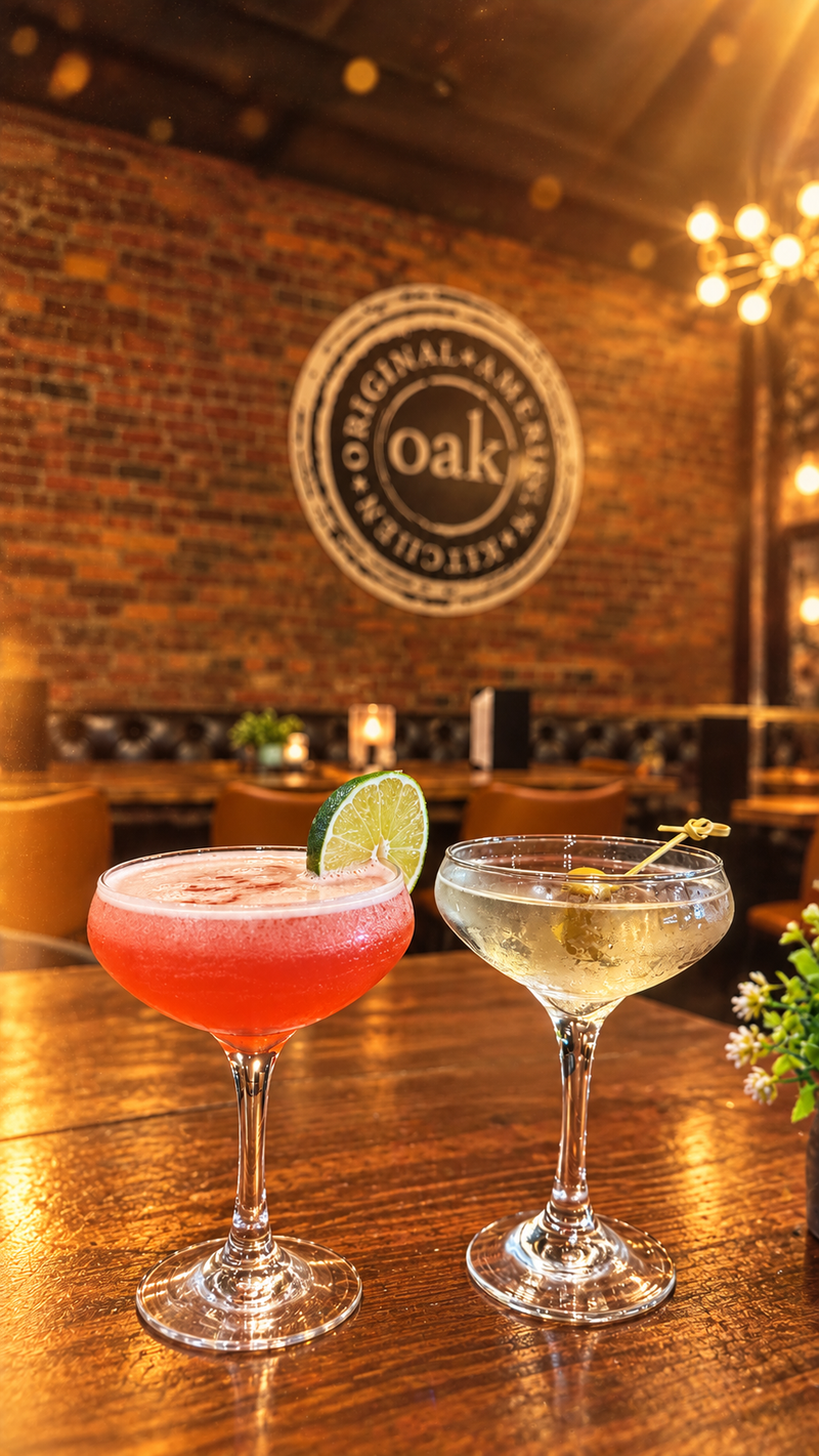 Two coupe cocktails on the bar under the OAK seal