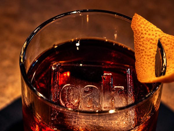 The Oak Old Fashioned with an orange peel, OAK etched into the ice