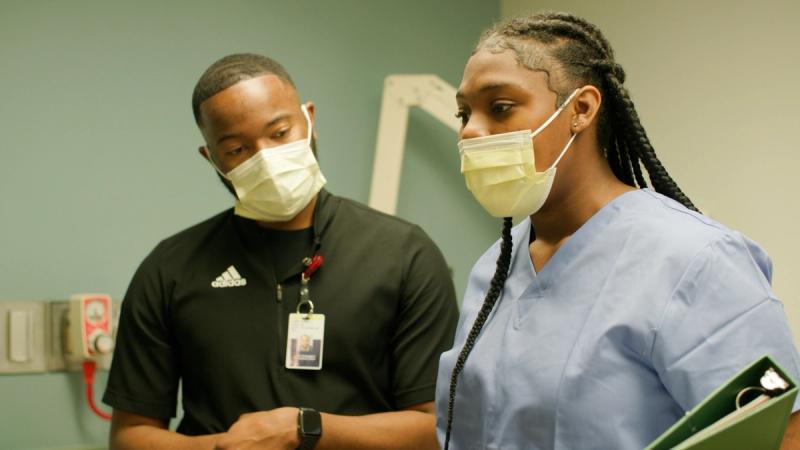Philadelphia high school student in scrubs receiving mentorship from hospital staff member at St. Christopher's Hospital