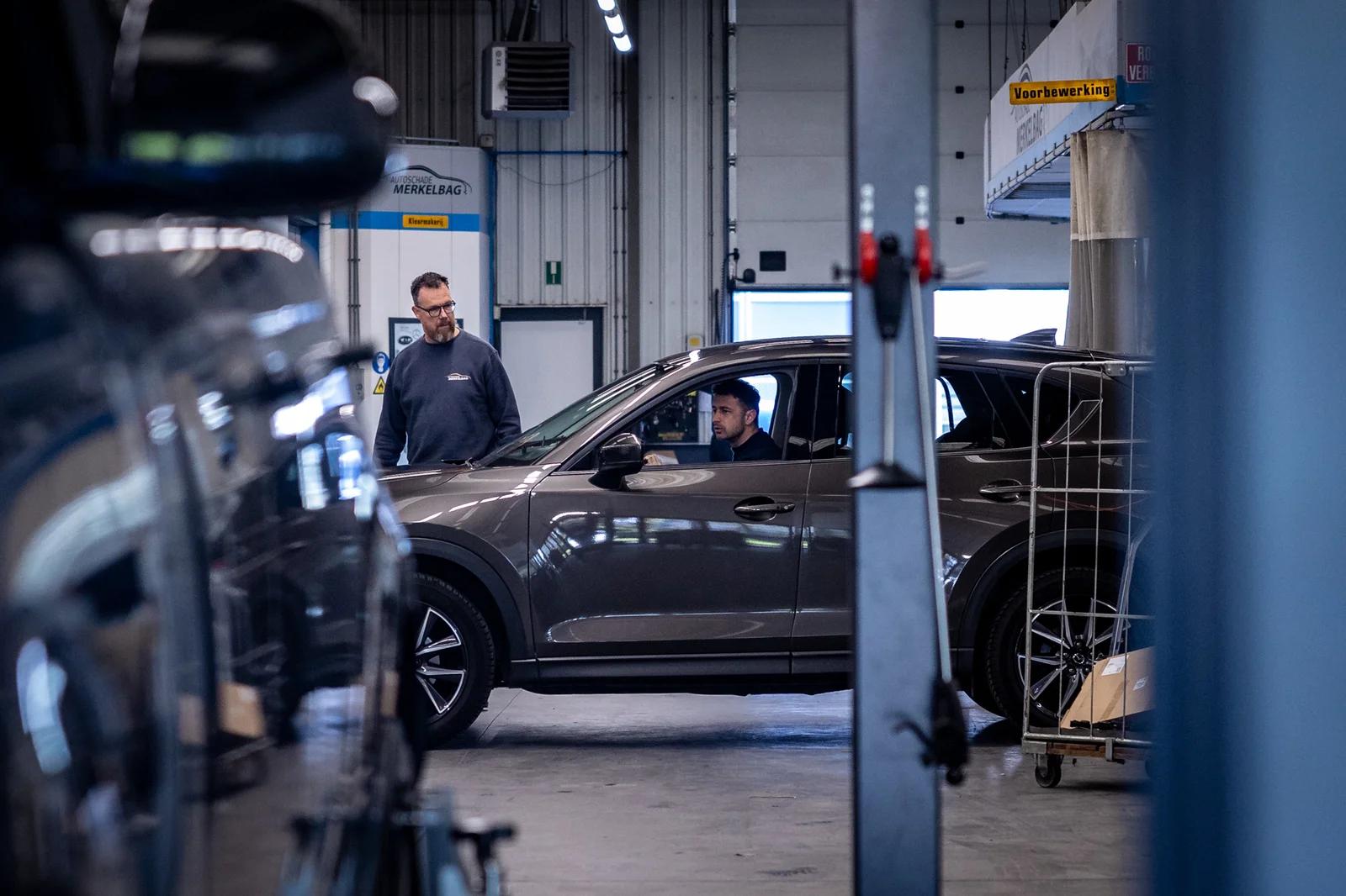 Twee beschadigde personenauto's die tegen elkaar staan bij het achteruit verlaten van een parkeervak.