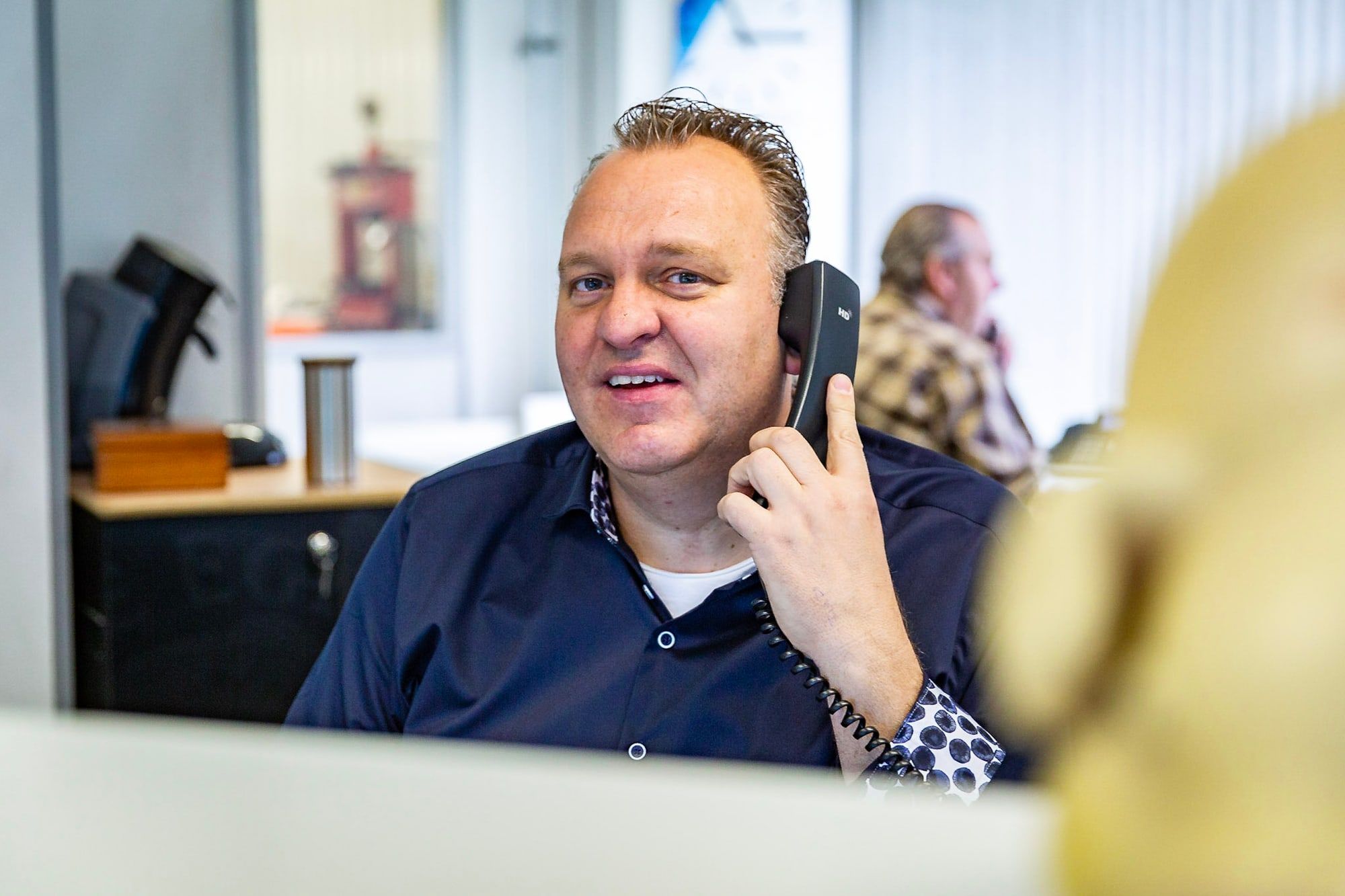 Medewerker van Autoschade Merkelbag helpt een klant telefonisch met het melden van autoschade