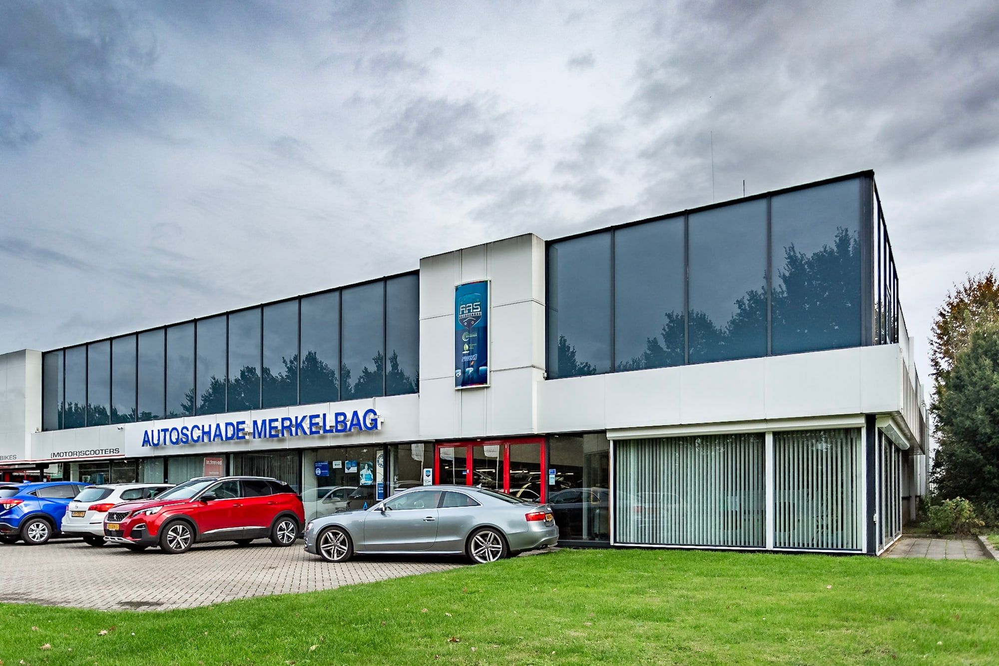 Het pand van Autoschade Merkelbag aan de Molensingel 21 op het Autoparc in Randwyck, Maastricht, met andere autobedrijven ernaast