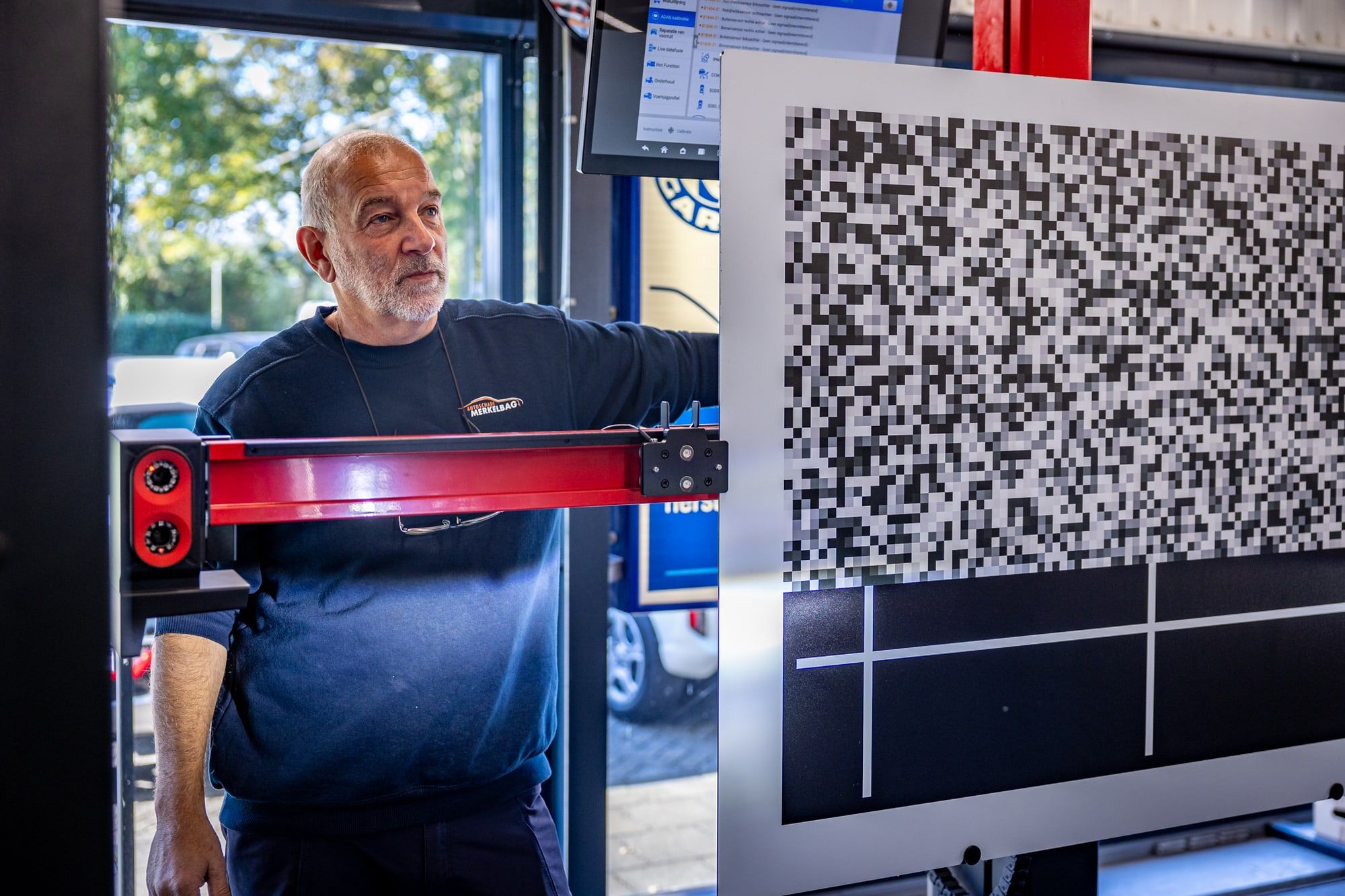 Technicus van Autoschade Merkelbag stelt een ADAS-richtbord op voor het kalibreren van de rijhulpsystemen na schade