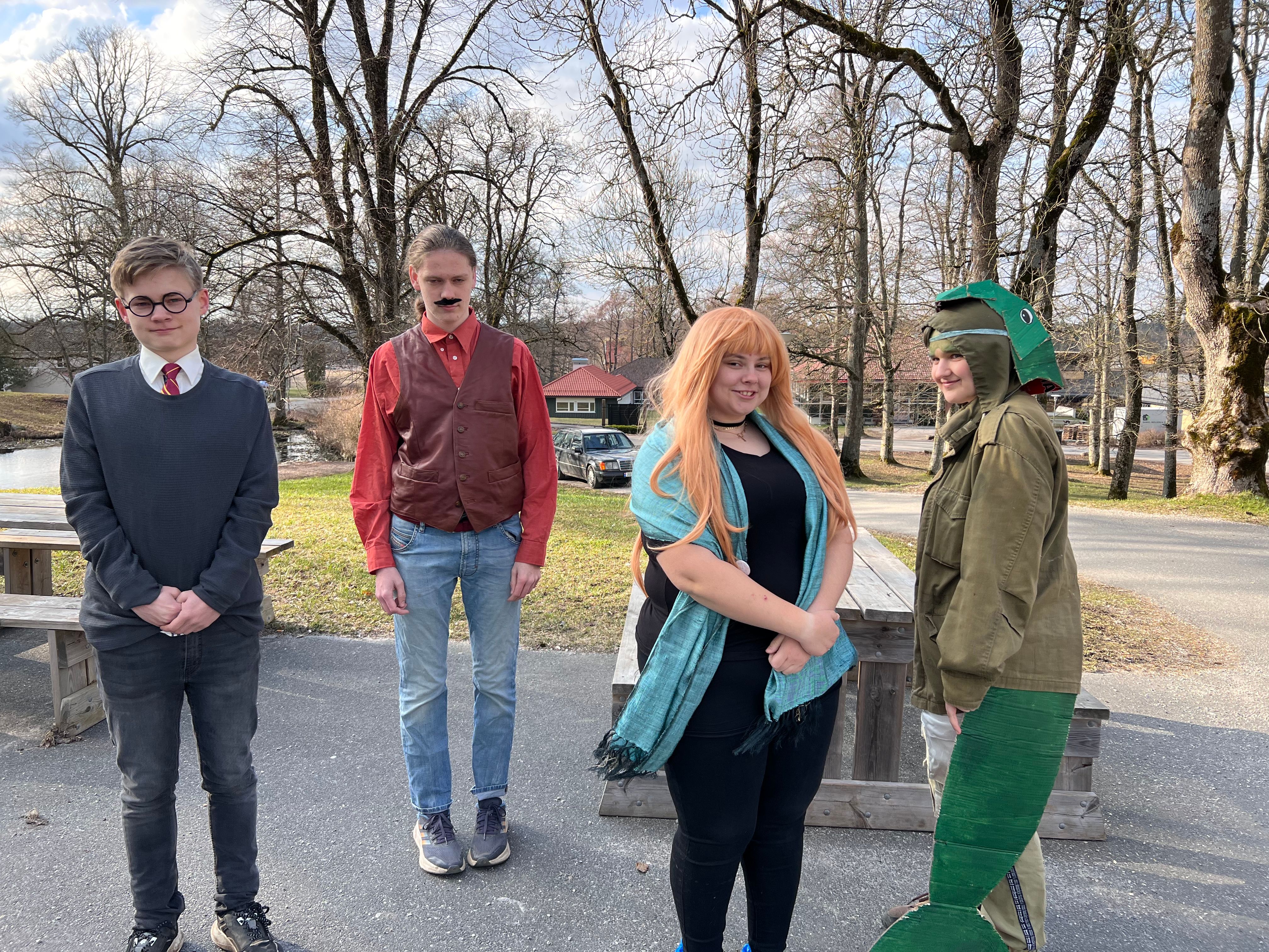 Fire personer står på rekke og rad.