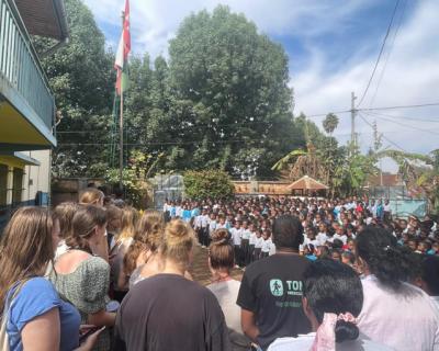 Elever står ute på rekker og synger