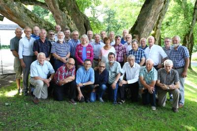 Kvinner og menn ved et tre i parken en sommerdag.