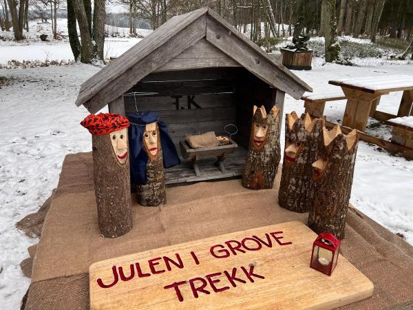Bilde av julekrybbe av vedkubber, med teksten 