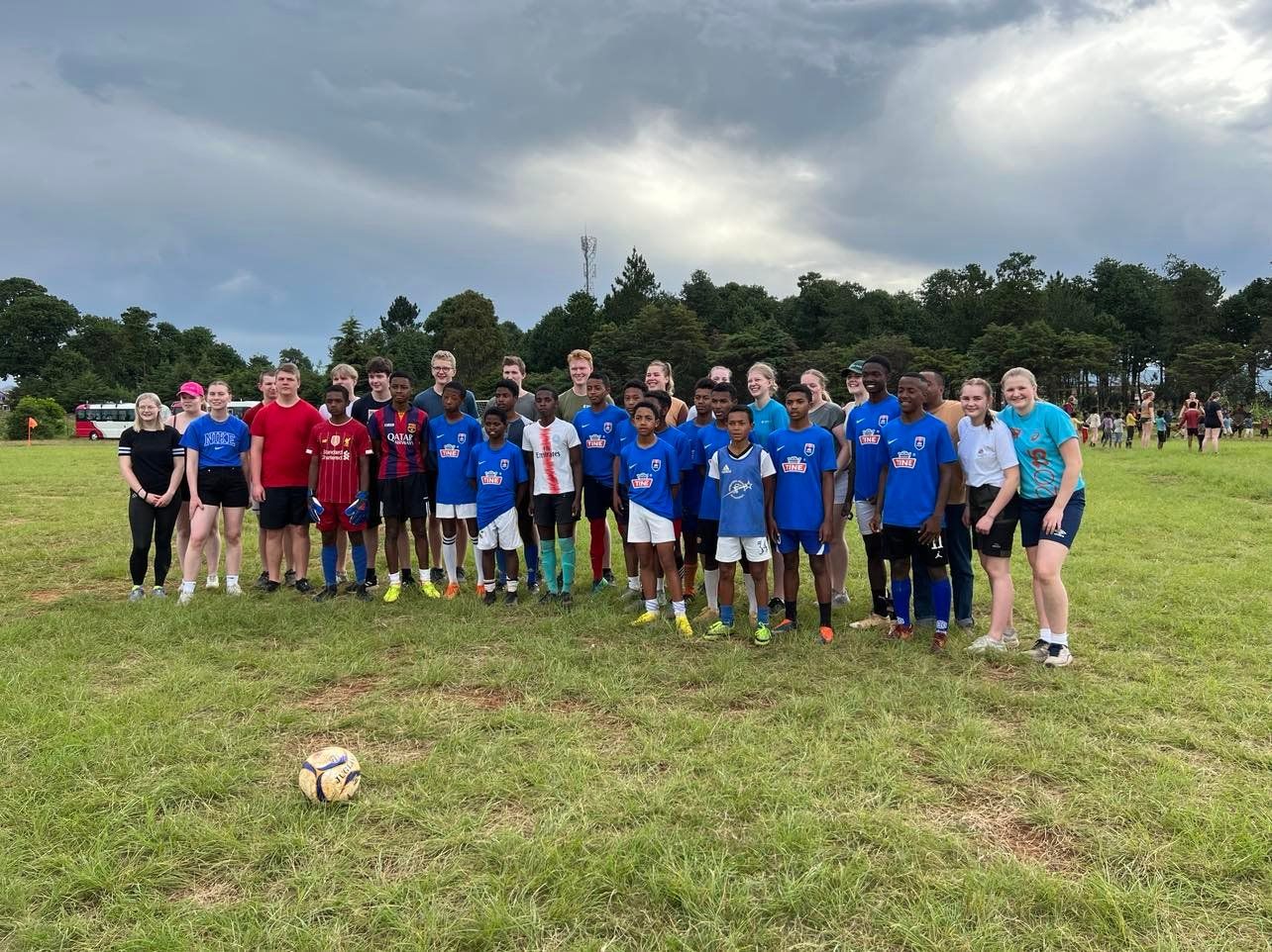 Fotballlag oppstilt, Tomb-elever og lokale barn.