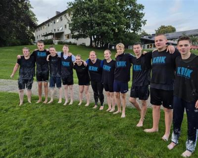 Et lag med spillere som står på rekke og holder hverandre på skuldrene.