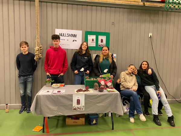 5 jenter og to gutter på stand. 
