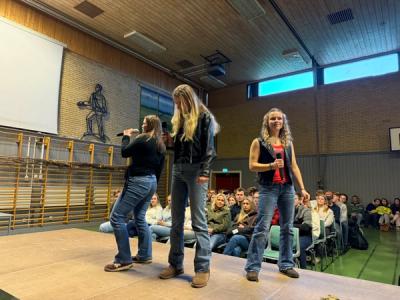 Tre elever synger fra scenen.