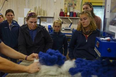 Elever blir forklart om hvordan garn spinnes i et verksted for spinning.