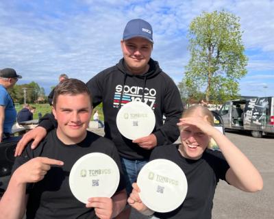 Tre elever som smiler, med disker.