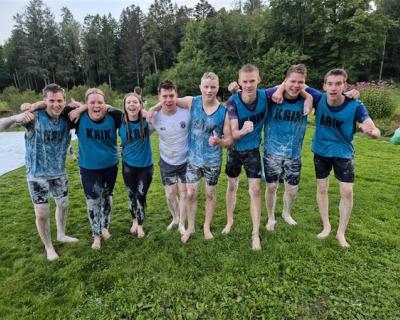 Et lag med spillere som står på rekke og holder hverandre på skuldrene.