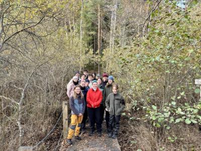 Mange elever i friluftsliv-klær oppstilt på en liten bro.