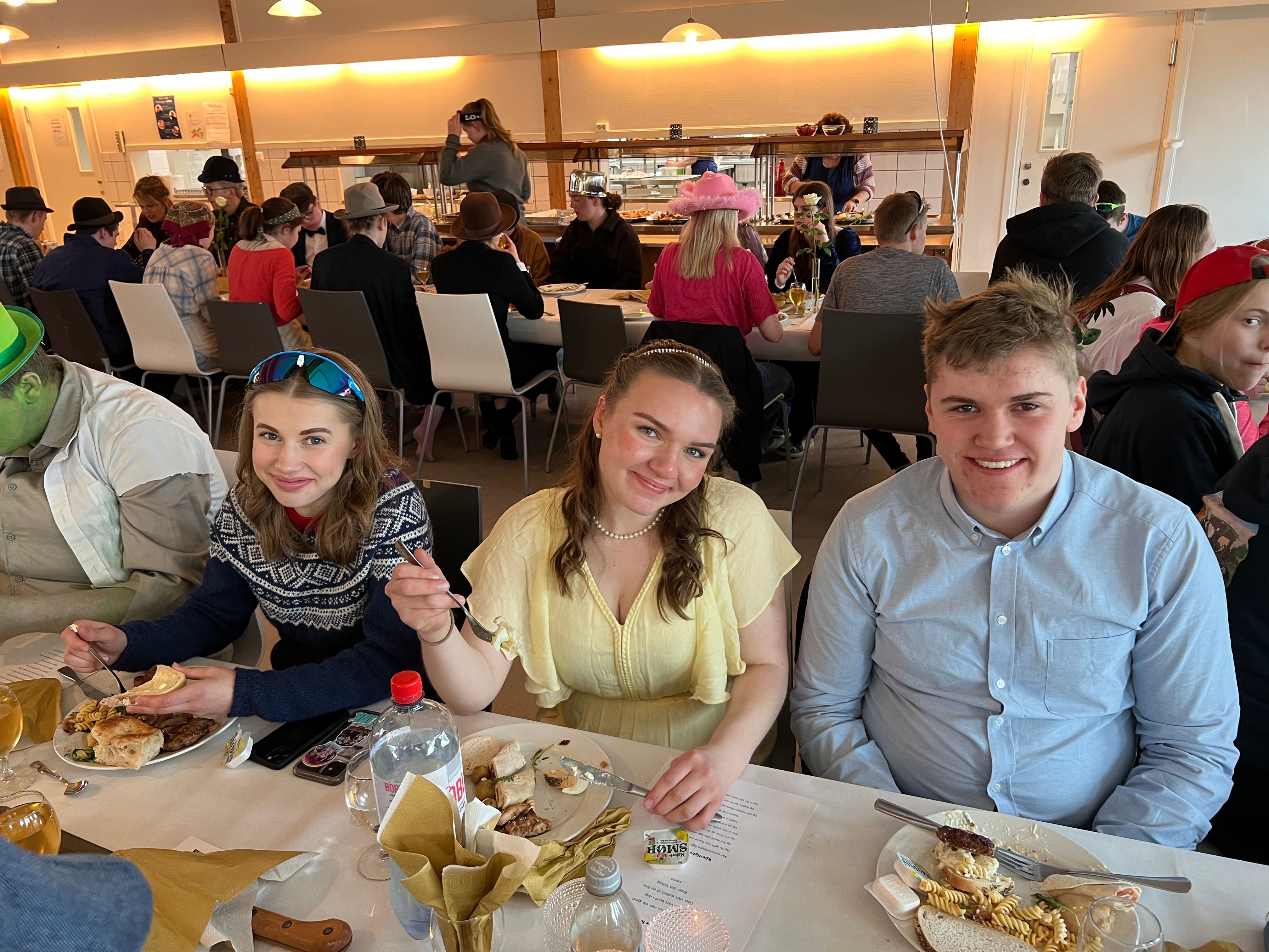 Tre personer ved bordet. 