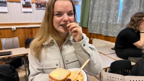 Jente som koser seg med maten