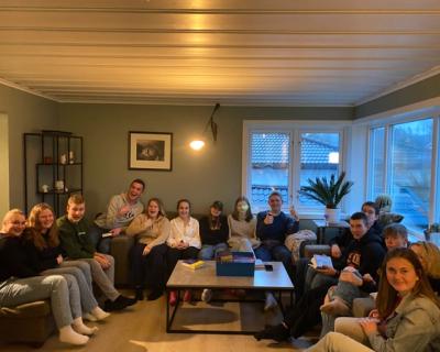 Mange ungdommer sitter i en stue.