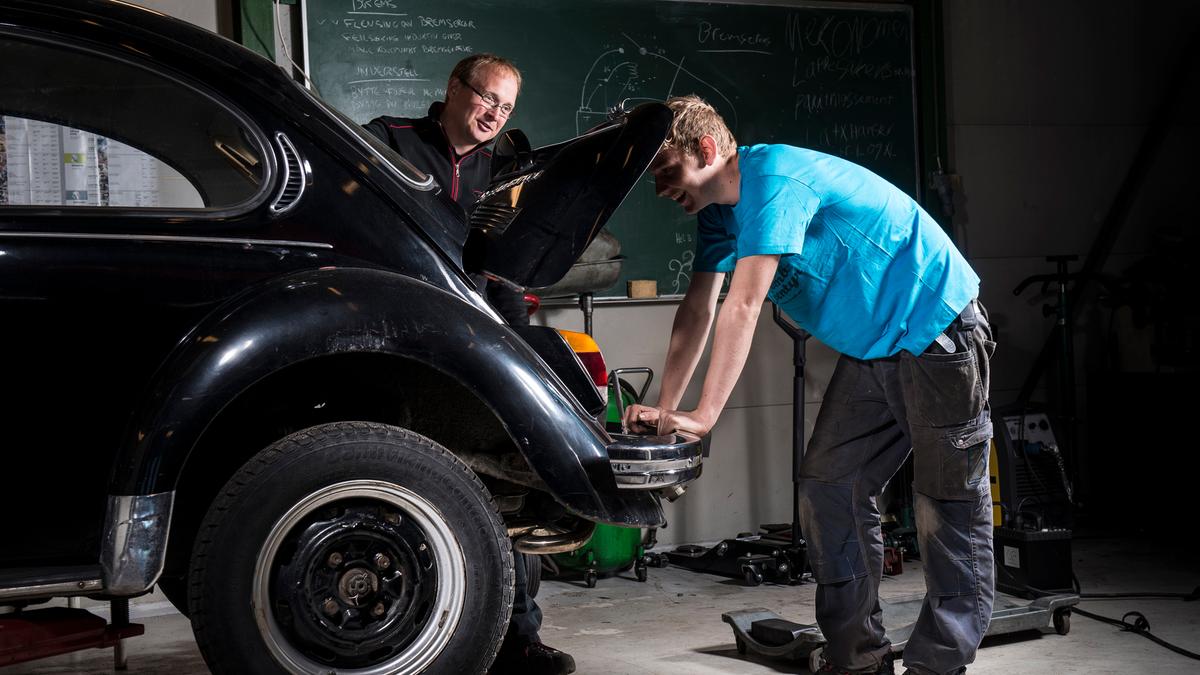 Lærer hjelper elev med bilen