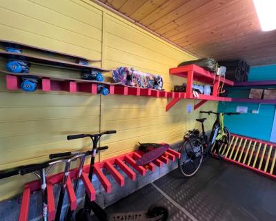 Bilde inni bua, rekker med sparkesykler, skateboard osv.