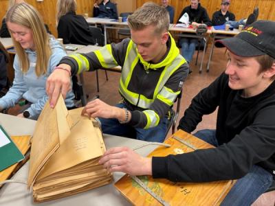 To elever i klasserommet blar i et gammelt herbarium
