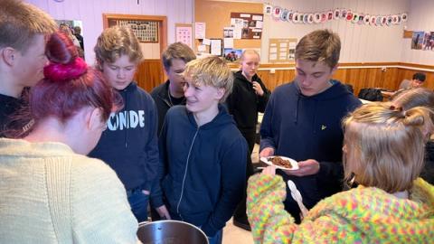 Mange elever rundt gryta