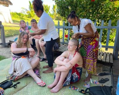 To jenter som får flettet håret.