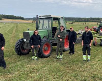 grasslåtten, elever og lærere står på jordet.
