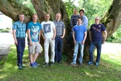 Unge menn ved et tre i parken en sommerdag.