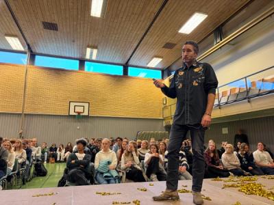 Mann taler og synger på en scene.