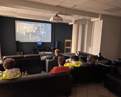 Elever i peisestua som ser på en serie.