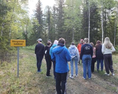 Elever står i skogen ved riksgrensa til Sverige.