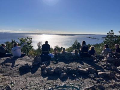 Elever sitter og ser utover havet. Nydelig vær. 