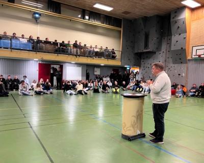 Ordføreren i aulaen, med elever som lytter