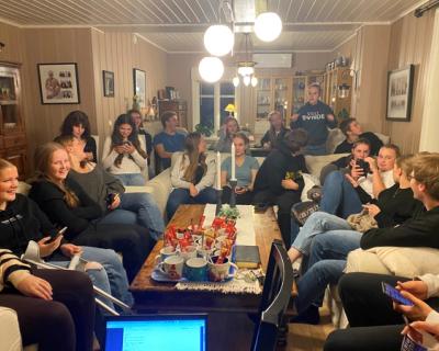 Mange ungdommer sitter i en stue.